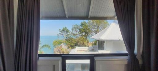 View through window showing outdoor scenery with ocean and trees