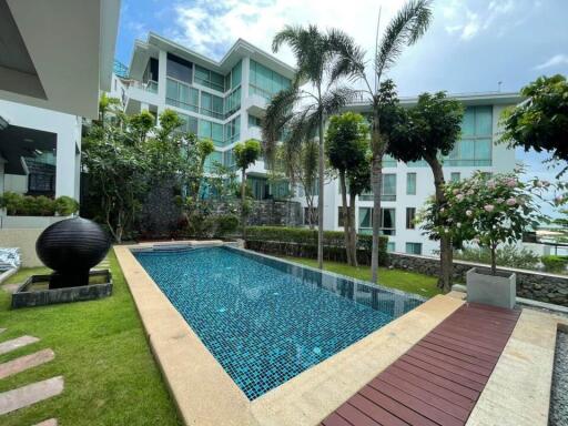 Modern building with outdoor pool and lush green surroundings