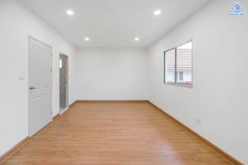 Empty room with wooden floor and white walls