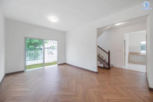 Spacious and well-lit living room with wooden flooring and large window