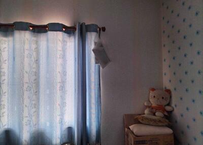 Bedroom with curtained window and a Hello Kitty plush