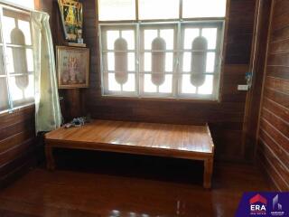 Wooden bedroom with bed frame and large windows