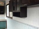 Modern kitchen with dark cabinetry and tiled walls