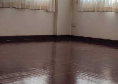 Unfurnished room with wooden flooring and large windows with sheer curtains