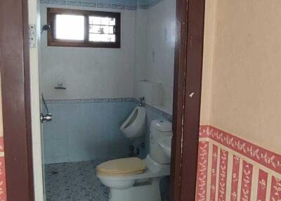 Bathroom with tiled floor, toilet, and window