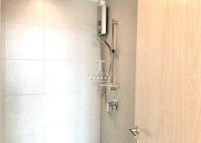 Bathroom with tiled walls and mounted shower unit