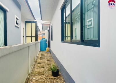 Narrow exterior passage with windows and a water tank