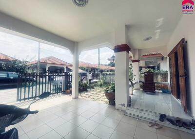 Covered outdoor patio with tiled flooring and seating area