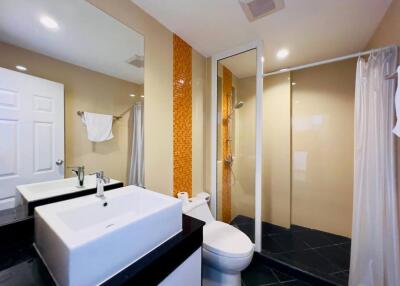 Modern bathroom with a large mirror, sink, toilet, and shower area