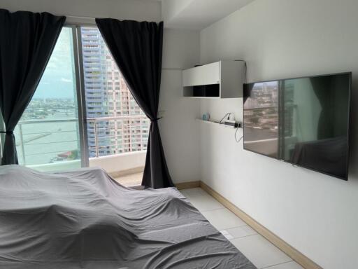 A bedroom featuring modern amenities and a balcony with a city view.