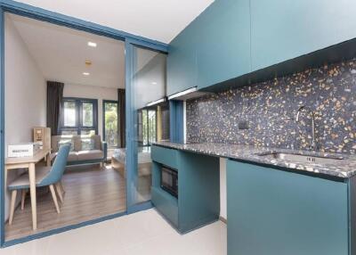 Modern kitchen with blue cabinetry and adjacent dining area