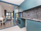 Modern kitchen with blue cabinetry and adjacent dining area