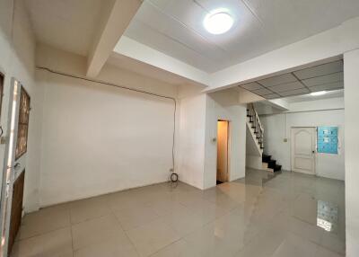 Spacious living area with tiled flooring and staircase