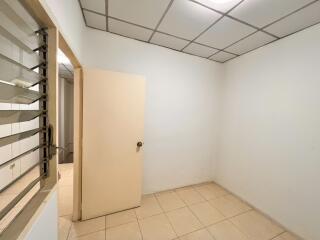 Empty room with beige tiles and white walls