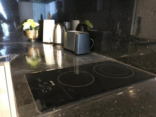 Modern kitchen with black countertop, induction stove, and appliances