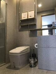Modern bathroom with toilet, shower, and mirrors