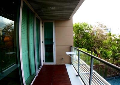 Modern balcony with wooden flooring and glass railing