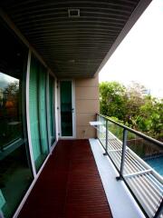 Modern balcony with wooden flooring and glass railing