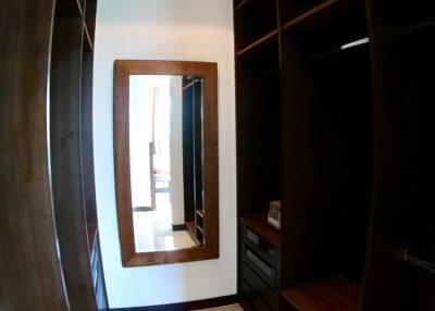 Spacious walk-in closet with shelving and a large mirror