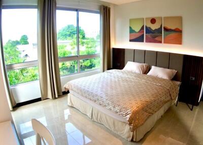 Bedroom with large windows and greenery view