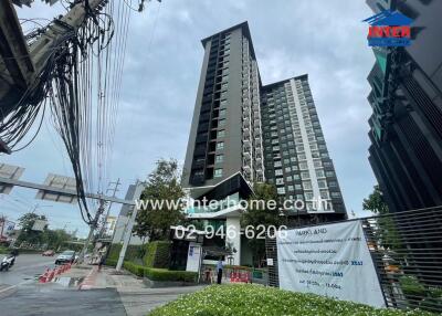 High-rise apartment building with entrance gate and surrounding area