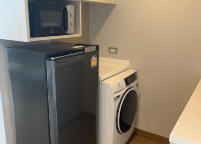 Laundry area with washing machine, dryer, microwave, and storage cabinets