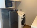 Laundry area with washing machine, dryer, microwave, and storage cabinets