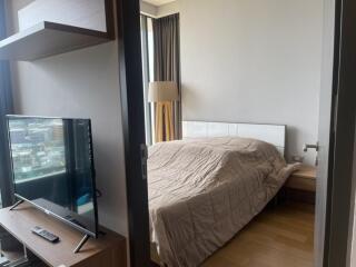 Bedroom with large bed, floor-length curtains, and TV