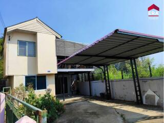 Exterior view of a two-story house with a carport