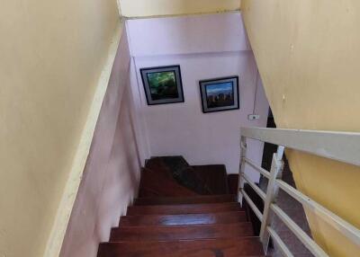 Indoor staircase with wooden steps and framed pictures on the wall