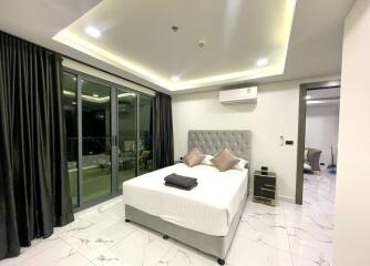 Modern bedroom with large windows and balcony access