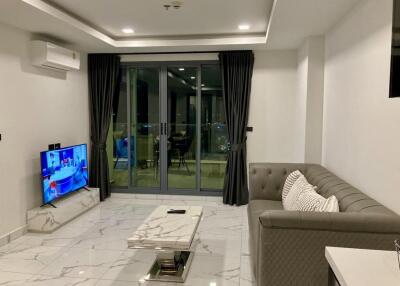 Modern living room with gray sofa and large glass doors