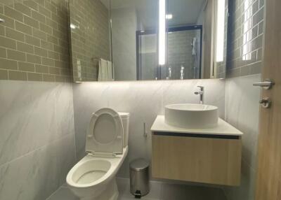 Modern bathroom with vanity, toilet, and large mirror