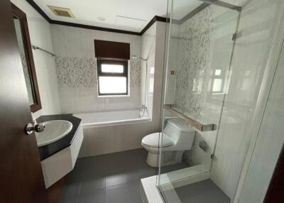 Modern bathroom with bathtub, sink, toilet, and glass-enclosed shower