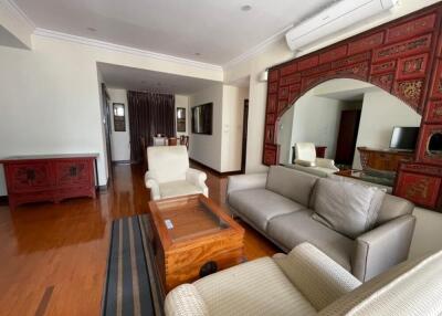 Living room with wooden flooring, sofa set, coffee table, and decorative mirror