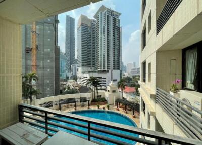 View of city from a balcony with a swimming pool below