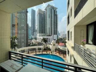 View of city from a balcony with a swimming pool below