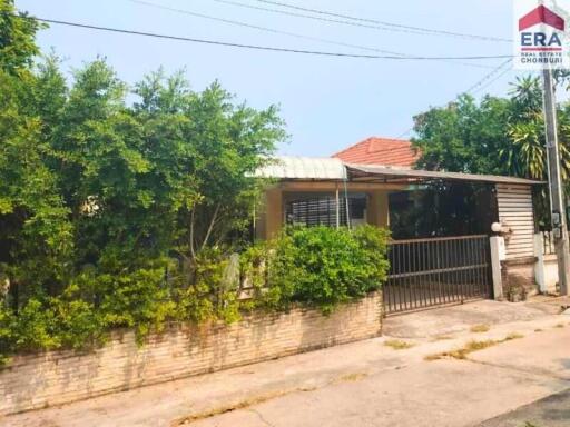 Front view of a residential house with a garden and a gated entrance