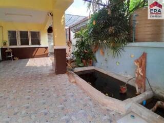 Outdoor area with tiled flooring, small fish pond, and plants