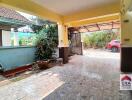 Covered carport or garage area with tiled floor and garden views