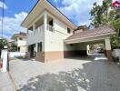 Two-story house with a driveway and a carport