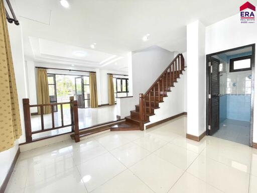 Spacious living area with natural light and staircase