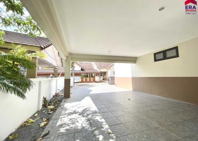 Covered garage with tiled flooring and partial view of driveway