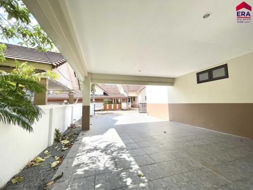 Covered garage with tiled flooring and partial view of driveway