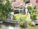 Aerial view of a residential house with yard and waterway