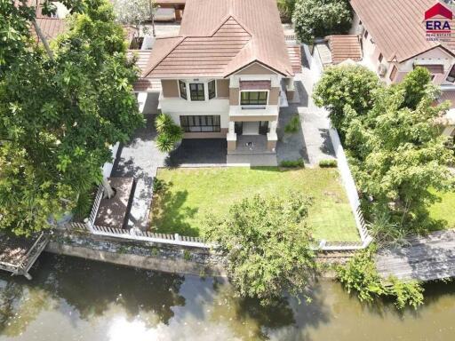 Aerial view of a residential house with yard and waterway