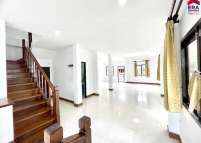 Spacious living area with large windows and wooden staircase