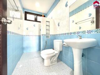 Well-lit bathroom with blue and white tiles