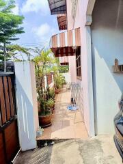 Outdoor corridor with potted plants and a gated entrance