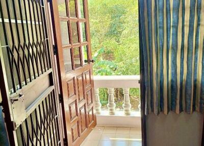 View of balcony with wooden door and security gate